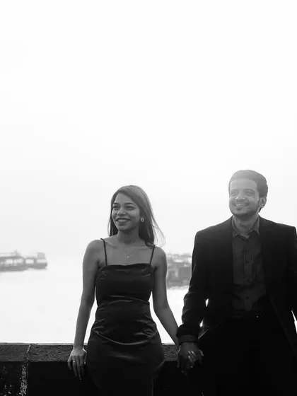 A classic black and white shot of the couple at the Gateway of India, with the harbor in the background, creating a timeless and nostalgic feel.