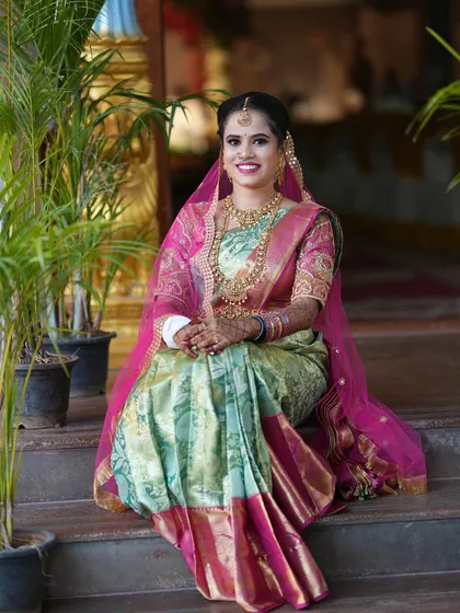 The bride seated on the steps, her beautiful saree elegantly spread around her. This pose creates a graceful and timeless bridal portrait.