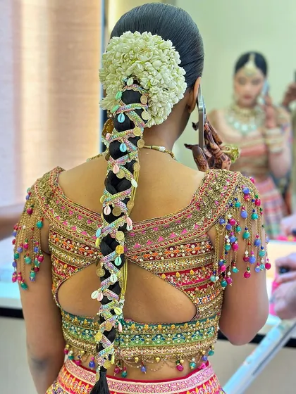 A festive and colorful braid for a Teej function. This look incorporates gota patti and vibrant shells, matching the joyous spirit of the occasion.