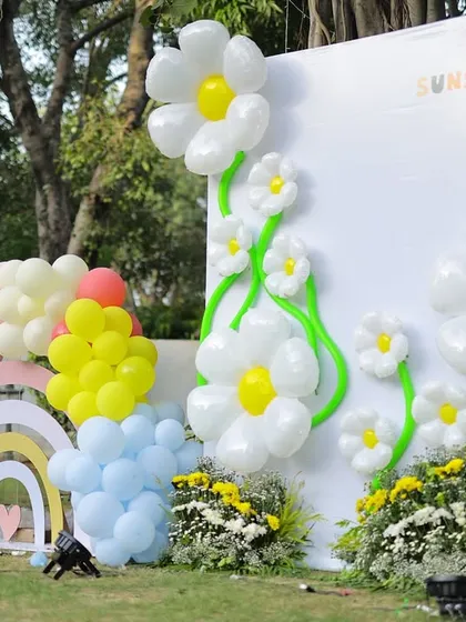 Another angle of the sunshine and daisy backdrop, showing how the balloon art and custom structures come together to create a cheerful and impressive focal point for an outdoor party.