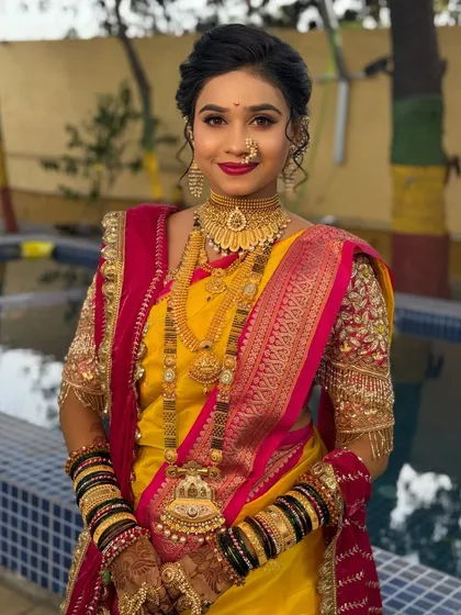A bride in a yellow and pink Nauvari, ready for her wedding ceremony.
