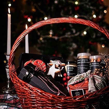 A festive red wicker basket filled with Christmas goodies, perfect for a Boxing Day gift. It’s a wonderful way to continue the celebrations and share the joy of the season with neighbours and friends.