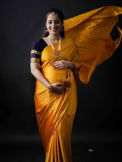 The flowing fabric of this golden yellow saree adds a dynamic and joyful element to this studio maternity portrait. We love capturing the radiant glow of mothers-to-be.