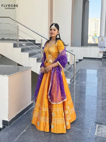 Looking for a stunning non-bridal lehenga? This vibrant orange and purple combination is perfect for a Mehendi or Sangeet. It's bright, bold, and beautiful.