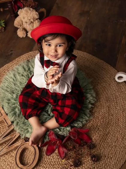 An overhead shot capturing this little guy's charming expression. The red hat adds a wonderful pop of color to the neutral, rustic tones of the set.