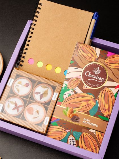 A duplicate of ID 29, this practical hamper includes an eco-friendly notebook with a pen and sticky notes, paired with a box of dark almond chocolates and other sweet treats.