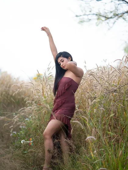 A dynamic pose in a field of tall grass, with the model's movement creating a sense of freedom and energy.