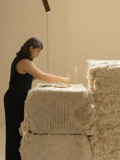 A member of the Studio Renn team arranges a piece in the exhibition. The design of the space is intended to be a neutral yet textured canvas, allowing the fine jewelry to be the primary focus.