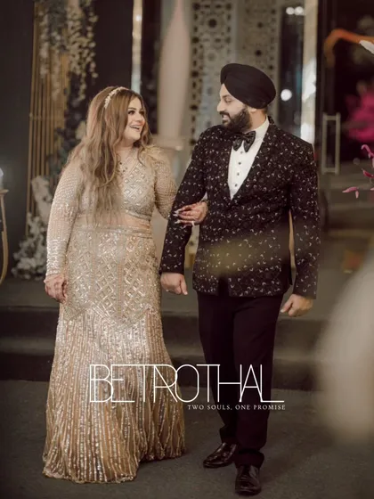 Gurbani and Gurneet walk arm-in-arm, sharing a look of love and happiness. The title 'Betrothal' marks this special occasion.