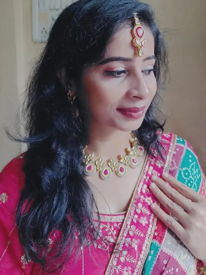 The ruby and kundan jewelry perfectly complements the colors in the bandhani dupatta.