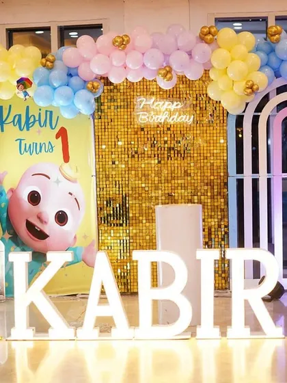 The full setup for Kabir's first birthday, with marquee letters and a complete Cocomelon backdrop.