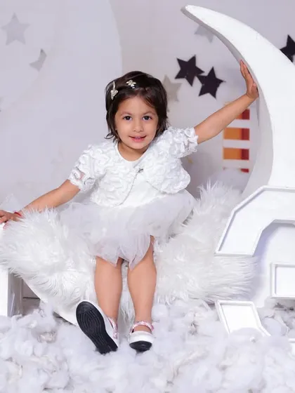 Celebrating three years with our dreamy moon and stars theme. This little girl is sitting on a giant number "3" shaped like a moon, dressed in a beautiful white tutu.