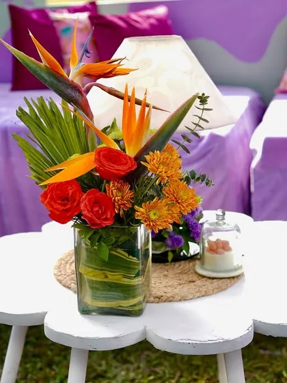 A close-up of a floral centerpiece on a flower-shaped table, part of a vibrant and playful Haldi decor scheme.