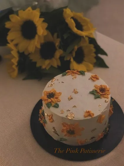 A rustic sunflower cake with specks of gold leaf, perfect for a sunny celebration.