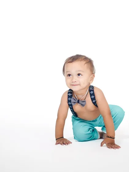 A dynamic crawling pose on a minimalist white background, highlighting the baby's movement and sweet expression.