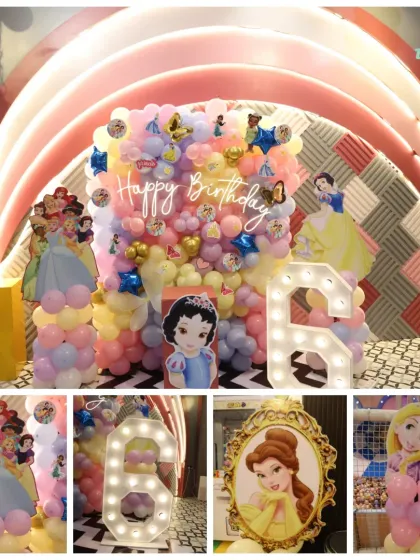 A dream come true for a princess fan. This party setup features decorations of multiple Disney princesses, a light-up number '6', and a beautiful balloon arch for photos.