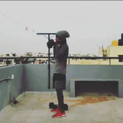 A student performing a dumbbell shoulder press on the rooftop. This exercise is great for building balanced shoulder strength and stability.