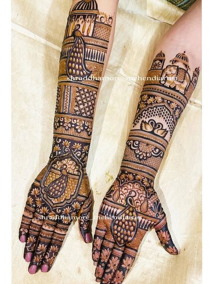 A stunning bridal design featuring multiple peacocks, swans, and a grand palace dome. The use of dark henna for filling creates a bold contrast that makes the motifs stand out.