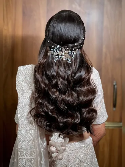 A view of the back, showcasing the beautiful wavy hairstyle with a pearl and crystal hair accessory.
