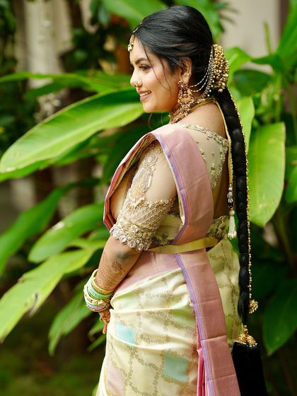 Another shot of the bride from the back, highlighting her long, braided hair adorned with traditional gold accessories.