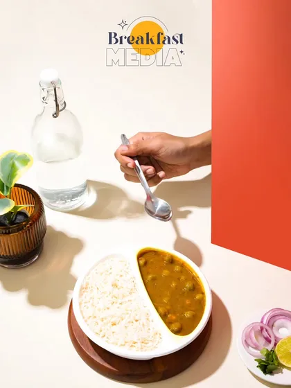 This composition uses strong lines, color blocking, and hard light to create a modern, architectural look. It's a highly stylized approach that makes a simple meal of chana and rice feel contemporary and cool.