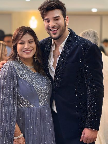 A candid moment showing the sparkling navy velvet blazer. It's designed to be comfortable enough to enjoy the party while still looking absolutely impeccable.