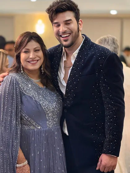 A candid moment showing the sparkling navy velvet blazer. It's designed to be comfortable enough to enjoy the party while still looking absolutely impeccable.