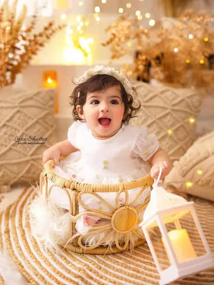 The brightest smile! This happy baby girl is holding a lantern, adding a touch of magic to her boho-themed birthday photos.