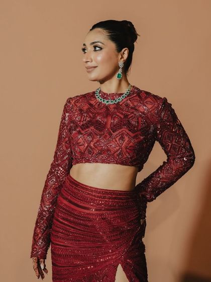 A close-up of a stunning red reception look. The statement blouse and slit skirt from Ritika Mirchandani are versatile pieces that can be styled again and again.