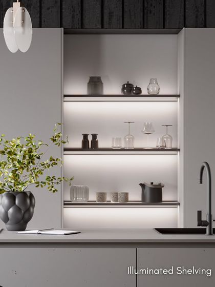 Illuminated shelving in this design creates a beautiful display niche, adding warmth and ambiance to the minimalist, modern kitchen.
