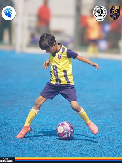 A young player shows great concentration and ball control during a match in Pune.