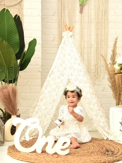 Celebrating her first birthday with a beautiful and timeless boho-chic theme. The delicate lace, natural textures, and soft lighting create an elegant and sweet portrait to mark this special milestone.