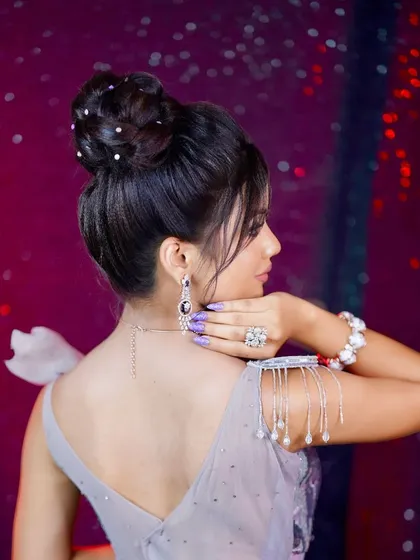 A back view of the elegant top-knot bun, adorned with scattered pearls for a touch of class.