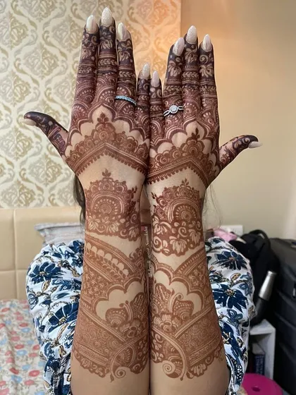 A full view of a gorgeous, dark henna stain, held up proudly by the client.