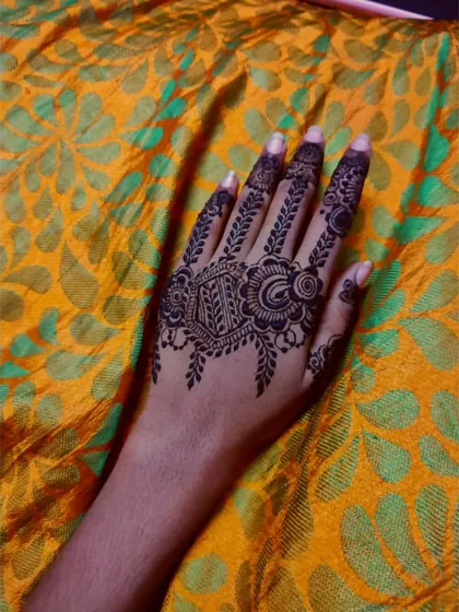 A classic Arabic-style design for the back of the hand, with a central motif and leafy patterns extending up the index finger.
