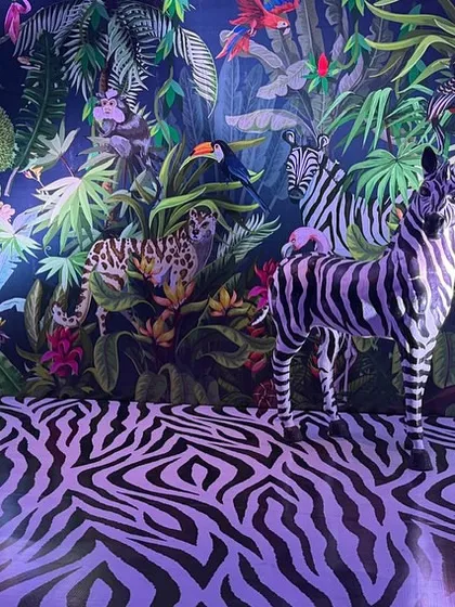 For a truly unique event, I created this immersive jungle paradise. The design features a custom-printed backdrop with exotic animals, a zebra-print floor, and a life-sized zebra statue, all surrounded by lush foliage. This is an example of how I build a complete thematic world for guests to step into.