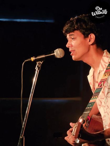 A musician serenading the crowd with his guitar. Our open mic nights welcome all forms of art.