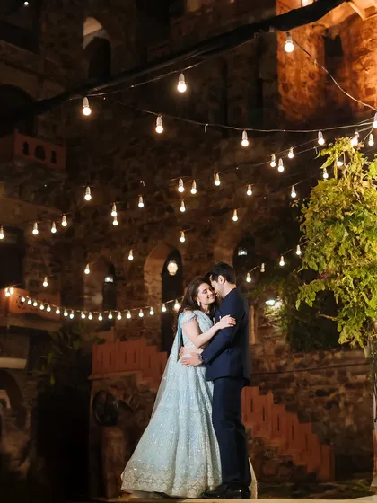 A fairytale first dance under a sky of twinkling lights. This frame captures the romance and magic of a sangeet night at the historic Fort Neemrana, surrounded by the warmth of family and friends.