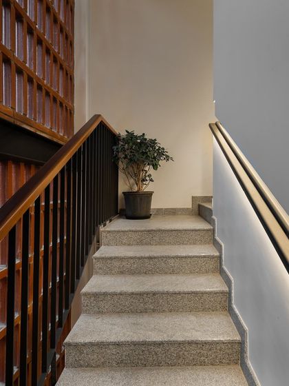 An identical view of the illuminated stairwell, highlighting the clean lines of the recessed handrail and the contrast between the smooth wall and the textured brick.
