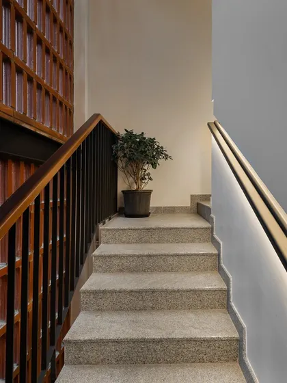 The main stairwell features a recessed, LED-lit handrail. This detail not only provides safe and subtle lighting but also makes the staircase feel more spacious and aesthetically clean.