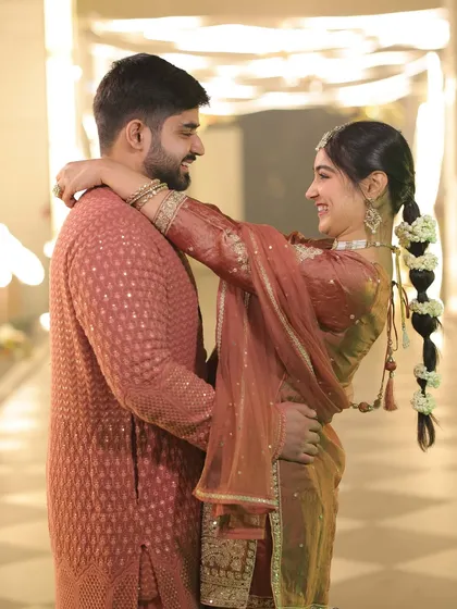 A playful moment captured during our pre-wedding puja. The rich, earthy tone of our outfits created a warm and unified look, perfect for a traditional and intimate family gathering.