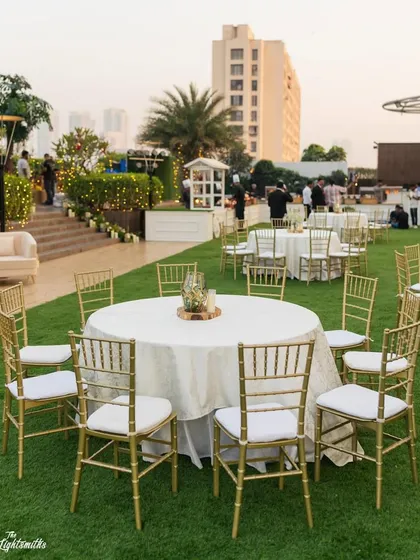Another view of the lawn seating arrangement, with simple, elegant tables and gold chiavari chairs.