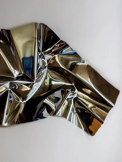 A close-up of "Meteor 67," a piece with a subtle gold tint that gives the stainless steel a warm, inviting glow.