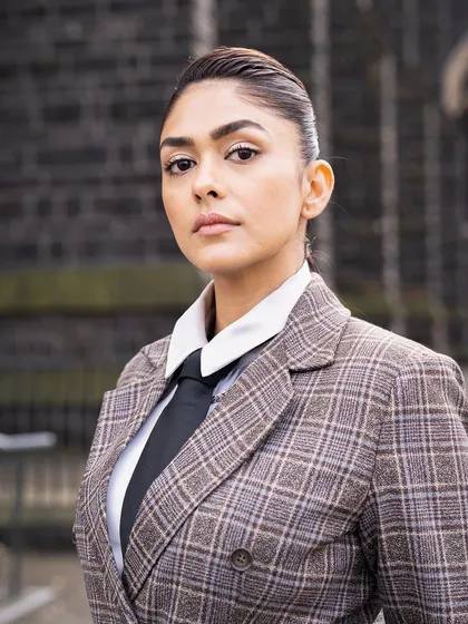A strong portrait in the plaid suit, highlighting the sharp tailoring and serious expression.