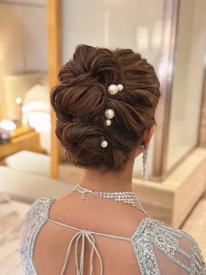 This is my signature "perfectly undone" look. I created this soft, textured messy bun to feel romantic and effortless, elevated with delicate pearl pins for a touch of class. It’s a versatile bridal updo that works beautifully for both the wedding ceremony and reception.