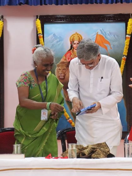 A moment of honor at the International Yoga Conference in Kanyakumari, with dignitaries on stage during the opening ceremony.