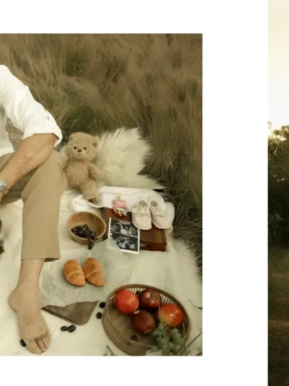 A close-up of the picnic setup, showing the thoughtful details like a teddy bear, baby shoes, and a basket of fruit. These props help to build the narrative of the shoot.