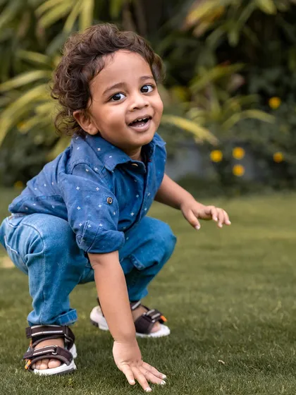 This outdoor child portrait captures the playful and curious spirit of this little explorer. During our sessions in Bangalore's parks, I let kids be themselves, which allows me to photograph their genuine expressions and personality against a beautiful, natural backdrop.