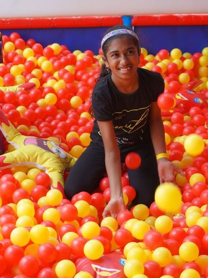 A happy girl enjoys our giant ball pit. It’s a fantastic sensory experience and a place where kids can play freely and safely.