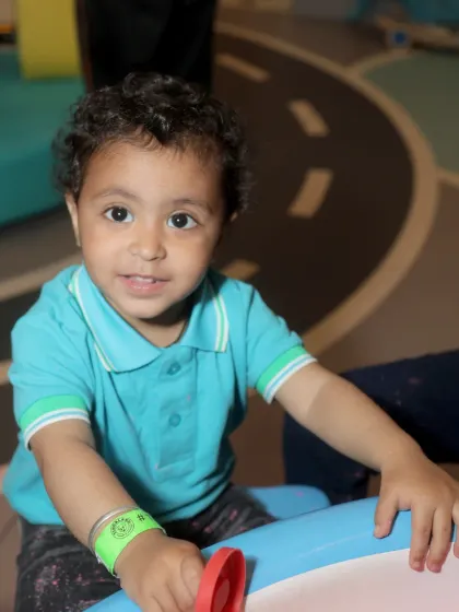 A close-up of a happy toddler engaged in sensory play at one of our activity tables.